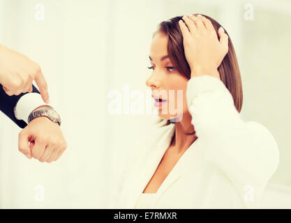 boss showing time to stressed businesswoman Stock Photo