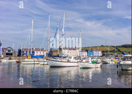 Aberaeron harbour surrounded by colourful regency styled houses and filled with sailing boats of all sizes in late summer sun. Stock Photo