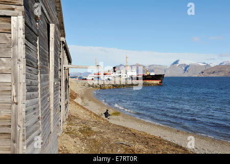 Wooden cabin with ship at the shore of Kings Bay, 23 August 2012 Stock Photo