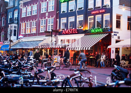 AMSTERDAM, NETHERLANDS - FEB 14, 2014: Unidentified people on the street of an old town of Amsterdam in the dusk. Stock Photo