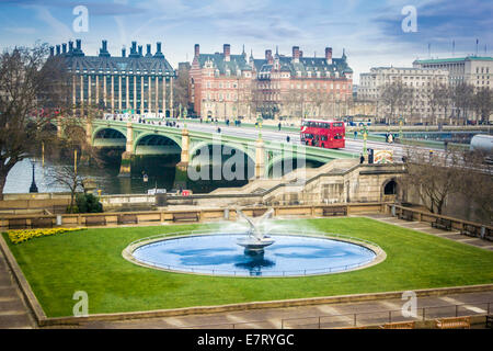 Fountain of St Thomas' Hospital and red London bus going over Westminster Bridge Stock Photo