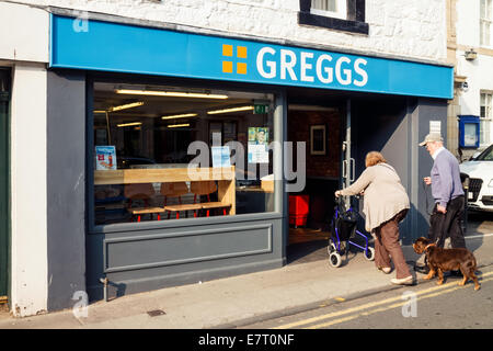 Elderly man and woman entering Greggs, High Street, North Berwick, East Lothian, Scotland Stock Photo