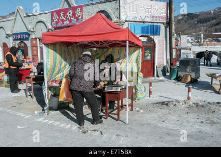 Woman selling meat in a Chinese village at -35oC, Xitong River near Hengdaohezi, Heilongjiang, China Stock Photo