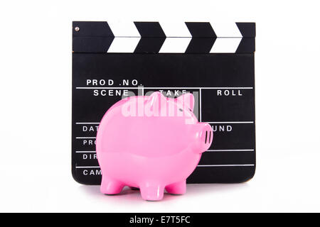 Black cinema clapper board with pink piggy bank, isolated on white background. Stock Photo