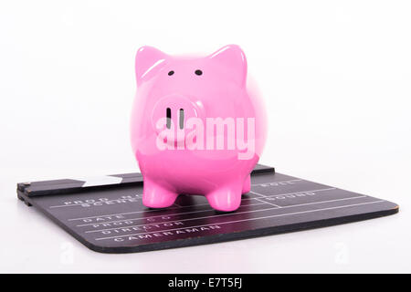 Black film clapper board with pink piggy bank, isolated on white background. Stock Photo