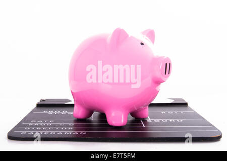 Black film clapper board with pink piggy bank, isolated on white background. Stock Photo