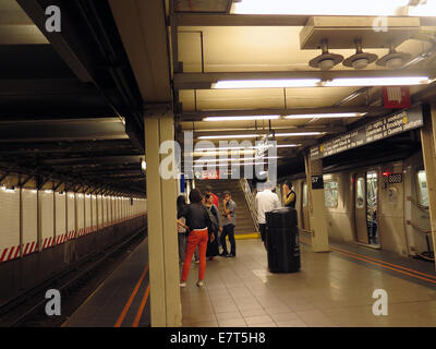 Passengers wait for the next train going Uptown from the 57th Street subway station in NYC. Stock Photo