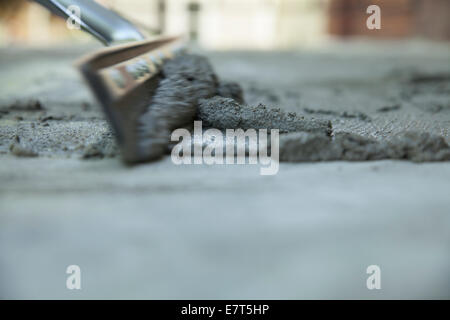 Workman smooths  a skim coating of cement on old stairway. Stock Photo