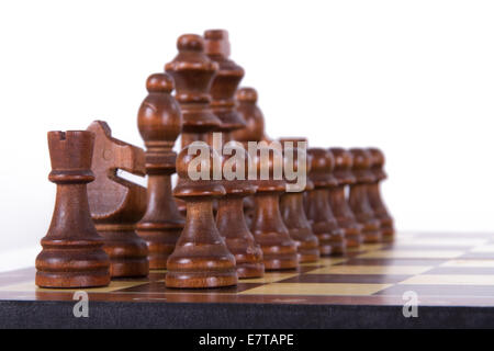 Chess board with starting positions aligned dark wooden chess pieces, isolated on white background. Stock Photo