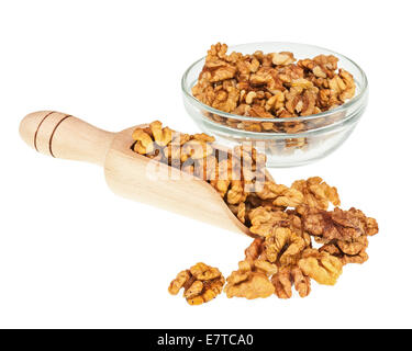 Handful of walnuts in scoop and glass bowl isolated on white background. Closeup. Selective focus. Stock Photo