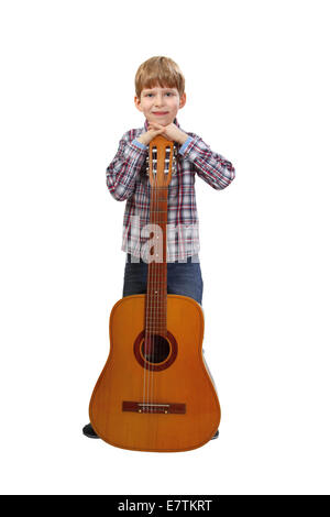 Boy stands relying on big acoustic guitar isolated on white background Stock Photo