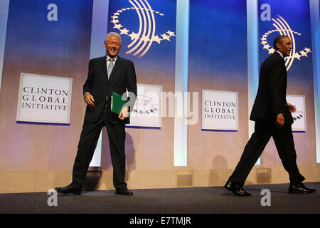 New York, USA. 23rd September, 2014. U.S. President Barack Obama, who is in New York City for the 69th Session of the United Nations General Assembly, walks past Bill Clinton on stage at the Clinton Global Initiative on September 23, 2014 in New York City. World leaders, activists and protesters have converged on New York City for the annual UN event that brings together the global leaders for a week of meetings and conferences. This year 's General Assembly has highlighted the problem of global warming and how countries need to strive to reduce greenhouse gas emissions. Credit: Spencer Platt  Stock Photo