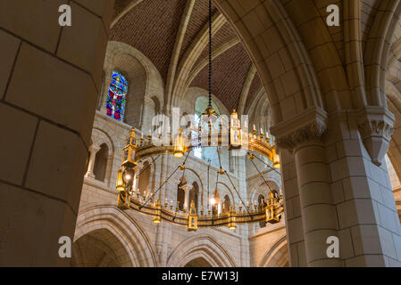 The interior of Buckfast Abbey hangs the chandelier Corona Lucis above the high altar and stained glass windows. Stock Photo