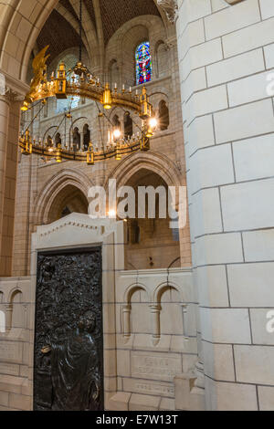 The interior of Buckfast Abbey showing the memorial plaque of Abbot Anscar and the chandelier and stained glass windows. Stock Photo