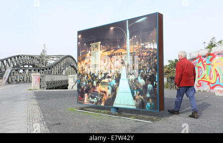 Berlin, Germany. 24th Sep, 2014. Visitors look at historic pictures on display on large panels at the former border crossing on Bornholmer Strasse (today known as the square 'Platz des 9th November') in Berlin, Germany, 24 September 2014. Berlin is commemorating the 25th anniversary of the Fall of the Berlin Wall on 9 November 2014. Photo: STEPHANIE PILICK/dpa/Alamy Live News Stock Photo