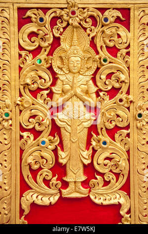 golden Buddha statue on wall Stock Photo