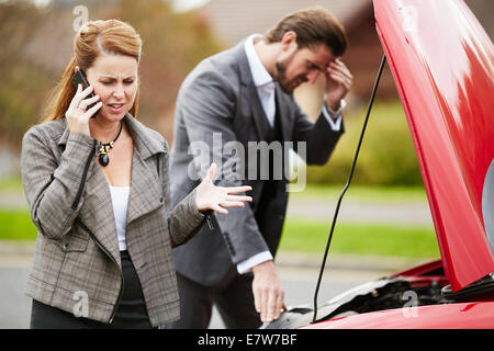 Couple with broken down car Stock Photo