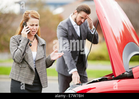 Couple with broken down car Stock Photo