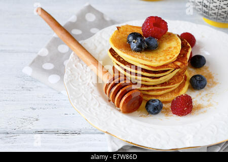 Pancakes with berries on a white plate, side view Stock Photo