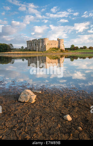 Carew Castle in Pembrokeshire, Wales. Mirror like reflections in the waters of the tidal mill that surround it Stock Photo