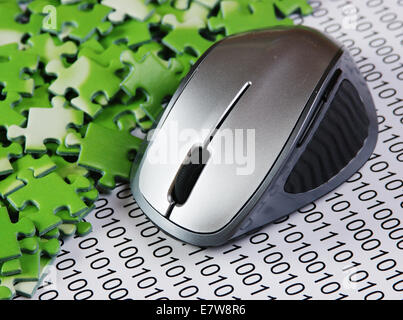 computer mouse and  puzzles on a binary code Stock Photo