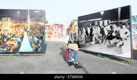 Berlin, Germany. 24th Sep, 2014. Visitors look at historic pictures on display on large panels at the former border crossing on Bornholmer Strasse (today known as the square 'Platz des 9th November') in Berlin, Germany, 24 September 2014. Berlin is commemorating the 25th anniversary of the Fall of the Berlin Wall on 9 November 2014. Photo: STEPHANIE PILICK/dpa/Alamy Live News Stock Photo