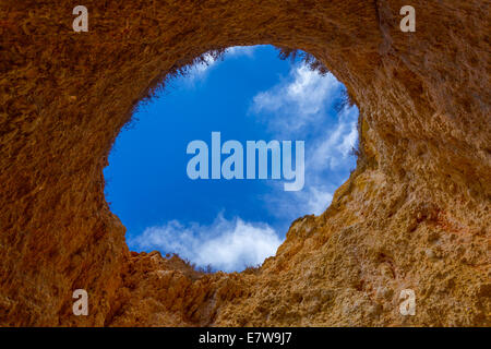 Hole of a big cave in the stones of the beach, Algarve Portugal Stock Photo