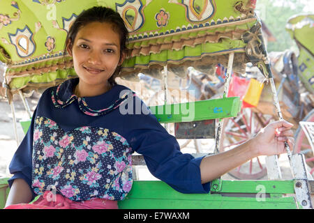 Young woman sitting in a traditional horse-drawn carriage at the Ava Stock Photo