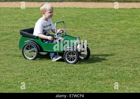 Young boy playing in an antique 1931 pedal car & 'parping' horn Stock Photo