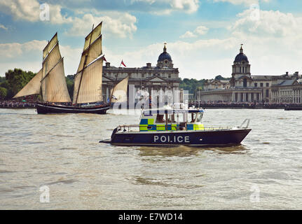 Police boat patrolling the river Thames, passing The Old Royal Naval College Greenwich. Stock Photo