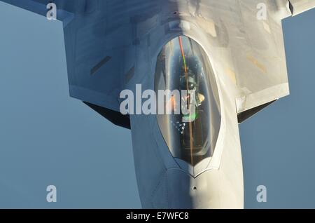 A US Air Force F-22 Raptor stealth fighter aircraft moves into position to refuel from a KC-10 Extender refueling aircraft during a combat sortie against ISIS targets September 23, 2014. The F-22 advanced fighter completed their first combat missions over Syria as the U.S. continues to strike at ISIS targets. Stock Photo