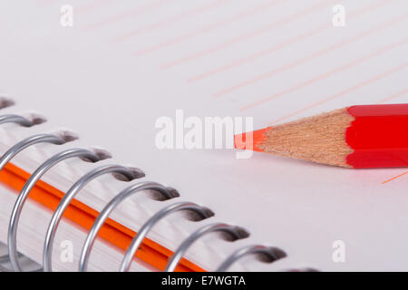 Red pencil on notebook with copyspace. Stock Photo