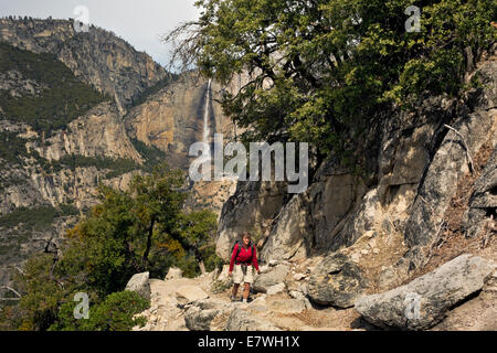 CA02324-00...CALIFORNIA - Hiker on the Four Mile Trail with Upper Yosemite Fall in the distance in Yosemite National Park. Stock Photo
