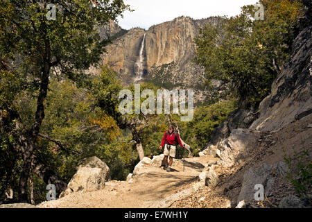 CA02325-00...CALIFORNIA - Hiker on the Four Mile Trail with Upper Yosemite Fall in the distance in Yosemite National Park. Stock Photo