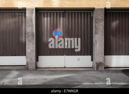 Brown metal garage gates with no parking road sign Stock Photo