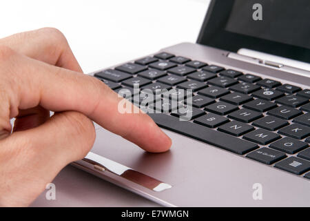 Index finger of hand touching touchpad on laptop, isolated on white. Stock Photo