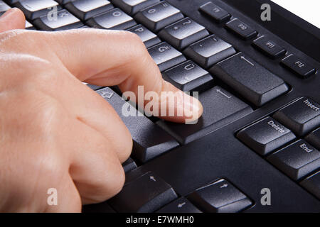 Index finger pressing enter key, button on keyboard. Stock Photo
