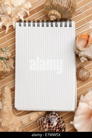 notebook on the background of mats and sea shells Stock Photo
