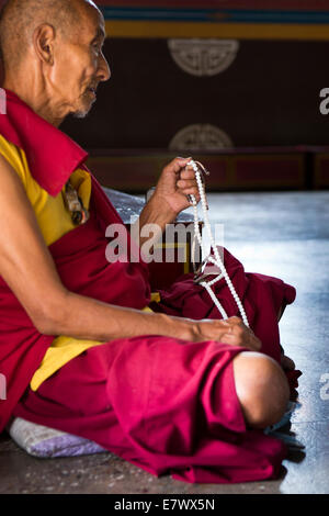 Eastern Bhutan, Trashigang, Rangjung Woesel Choeling Monastery hands of monk with prayer beads Stock Photo