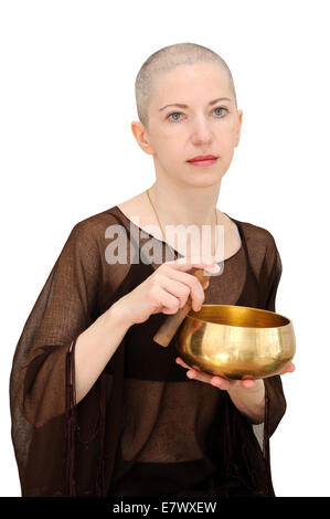 Bald woman in brown with singing bowl, meditating. Isolated on white, clipping path included. Stock Photo