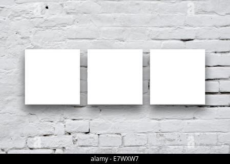 Three Square Posters hanging on the art gallery white wall. Stock Photo