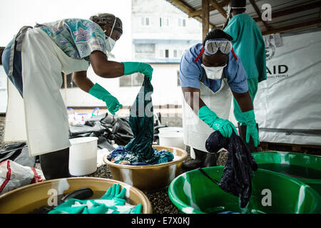 Health workers clean hospital scrubs and protective gear at the newly opened Island Clinic for Ebola treatment September 22, 2014 in Monrovia, Liberia. The facility opened by the WHO and the Ministry of Health in response to the surge of patients needing an Ebola Treatment. Stock Photo