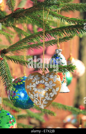 Vintage style heart-shaped Christmas decoration hangs  from a Christmas tree, England ,UK Stock Photo