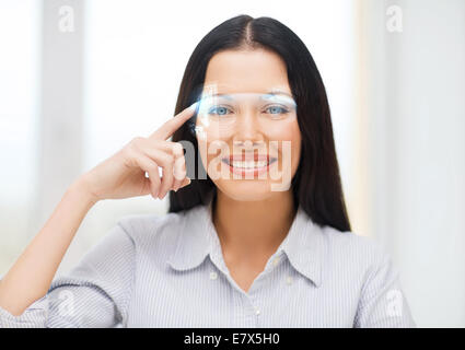 smiling woman pointing to futuristic glasses Stock Photo
