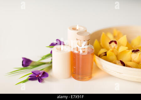 orchid flowers in bowl, oil, candles and irises Stock Photo