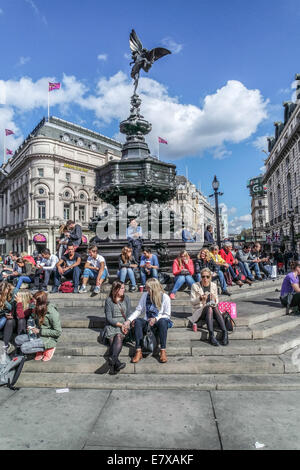 Piccadilly Circus Circus,London, Tourists sit on the Steps of the Eros Statue Stock Photo