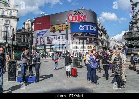 Piccadilly Circus, London, A police man gives direction to a tourist Stock Photo