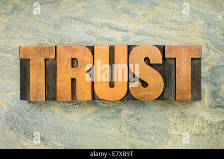 trust - a word in vintage letterpress wood type on a green slate rock background Stock Photo