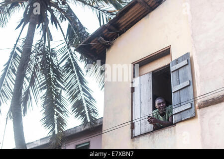 african man using cell phone at window Stock Photo