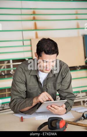 Carpenter Using Digital Tablet At Table Stock Photo